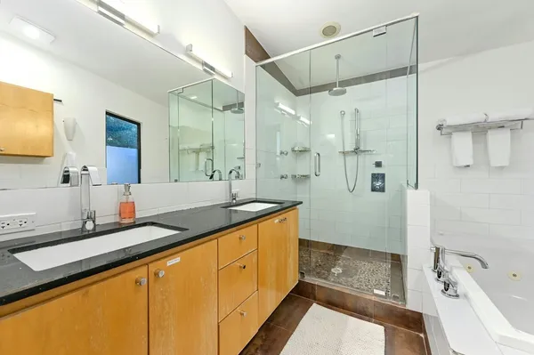 a spacious bathroom with a granite countertop sink mirror and a bathtub