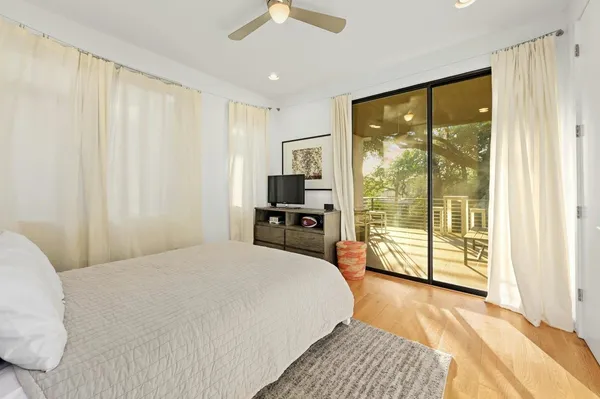 a bedroom with a large bed and a large window with the outer view