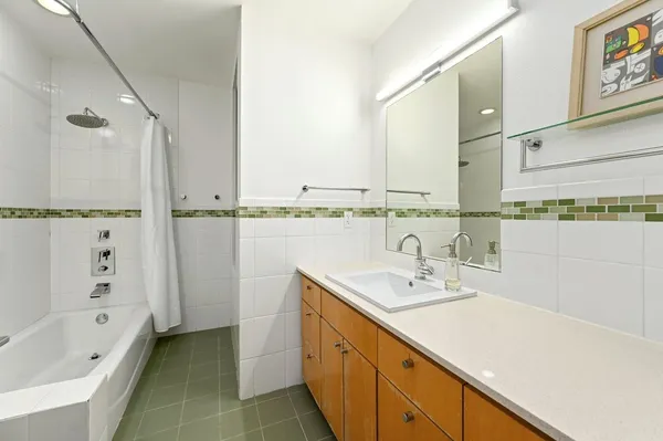 a bathroom with a tub sink and mirror