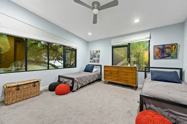 a bedroom with furniture and large windows