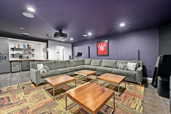 a living room with furniture a rug and kitchen view