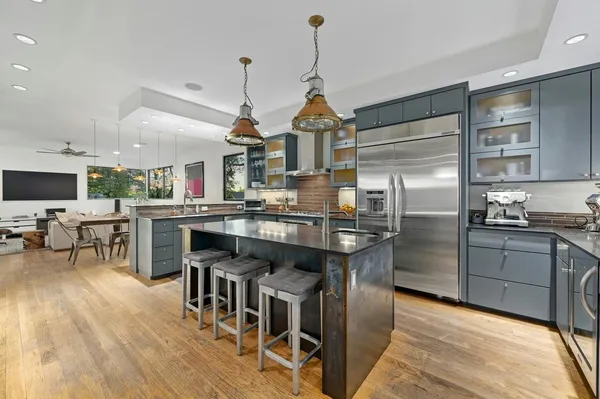 a kitchen with stainless steel appliances granite countertop a kitchen island a stove a table and chairs