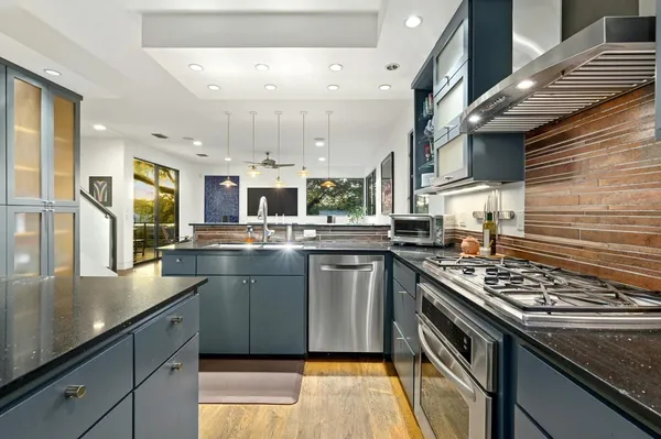 a kitchen with stainless steel appliances granite countertop a stove and a sink