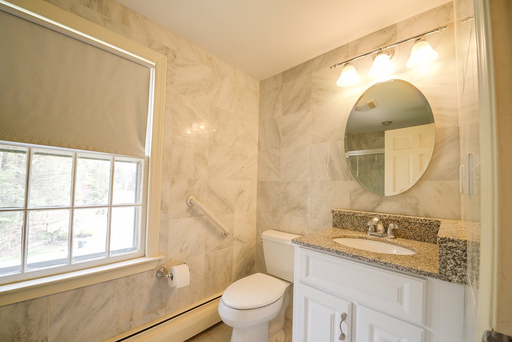 60 Woodcrest Road Boxford, MA 01921 - Photo 14 of 23 a bathroom with a granite countertop sink mirror vanity and toilet
