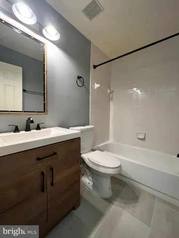 a bathroom with a double vanity sink toilet and shower