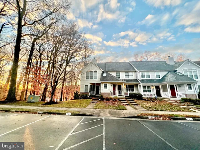 a front view of a building with large trees