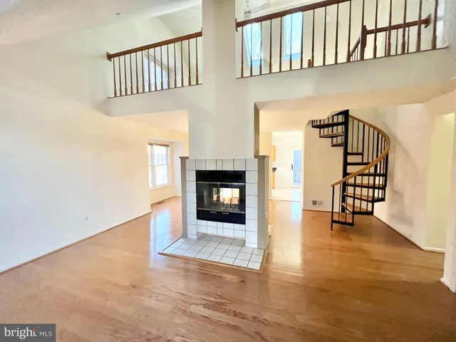 an empty room with windows and fireplace
