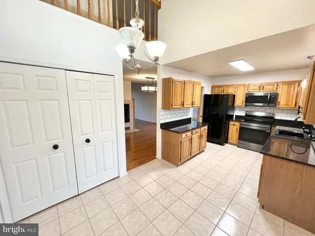 a kitchen with stainless steel appliances kitchen island granite countertop a refrigerator and a sink
