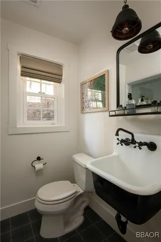 a bathroom with a sink a toilet and a window
