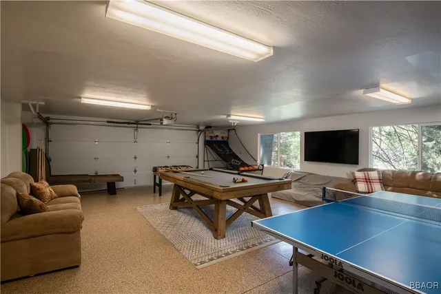 a living room with furniture pool table and a flat screen tv