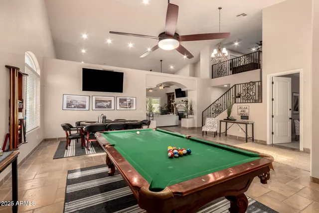 a kitchen with stainless steel appliances granite countertop a stove top oven a refrigerator a sink and a dining table with chairs