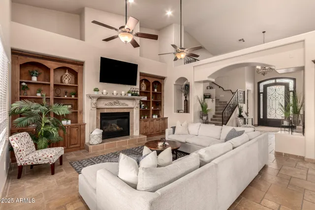 a bedroom with a bed a flat screen tv and a chandelier