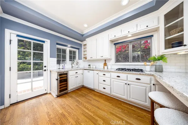 a kitchen with granite countertop a sink cabinets stainless steel appliances and a counter top space