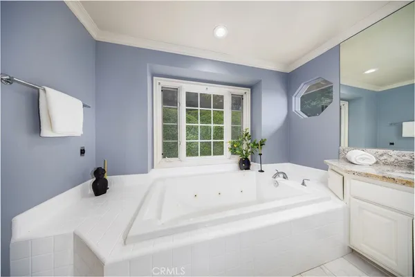 a bathroom with a tub a sink and mirror