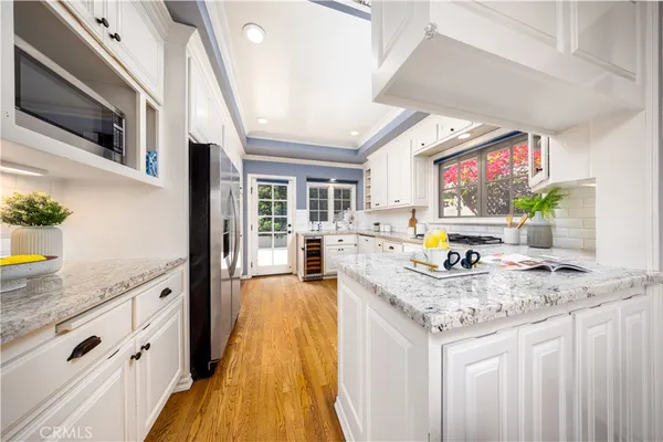 a kitchen with stainless steel appliances granite countertop a sink a stove top oven a counter space and cabinets