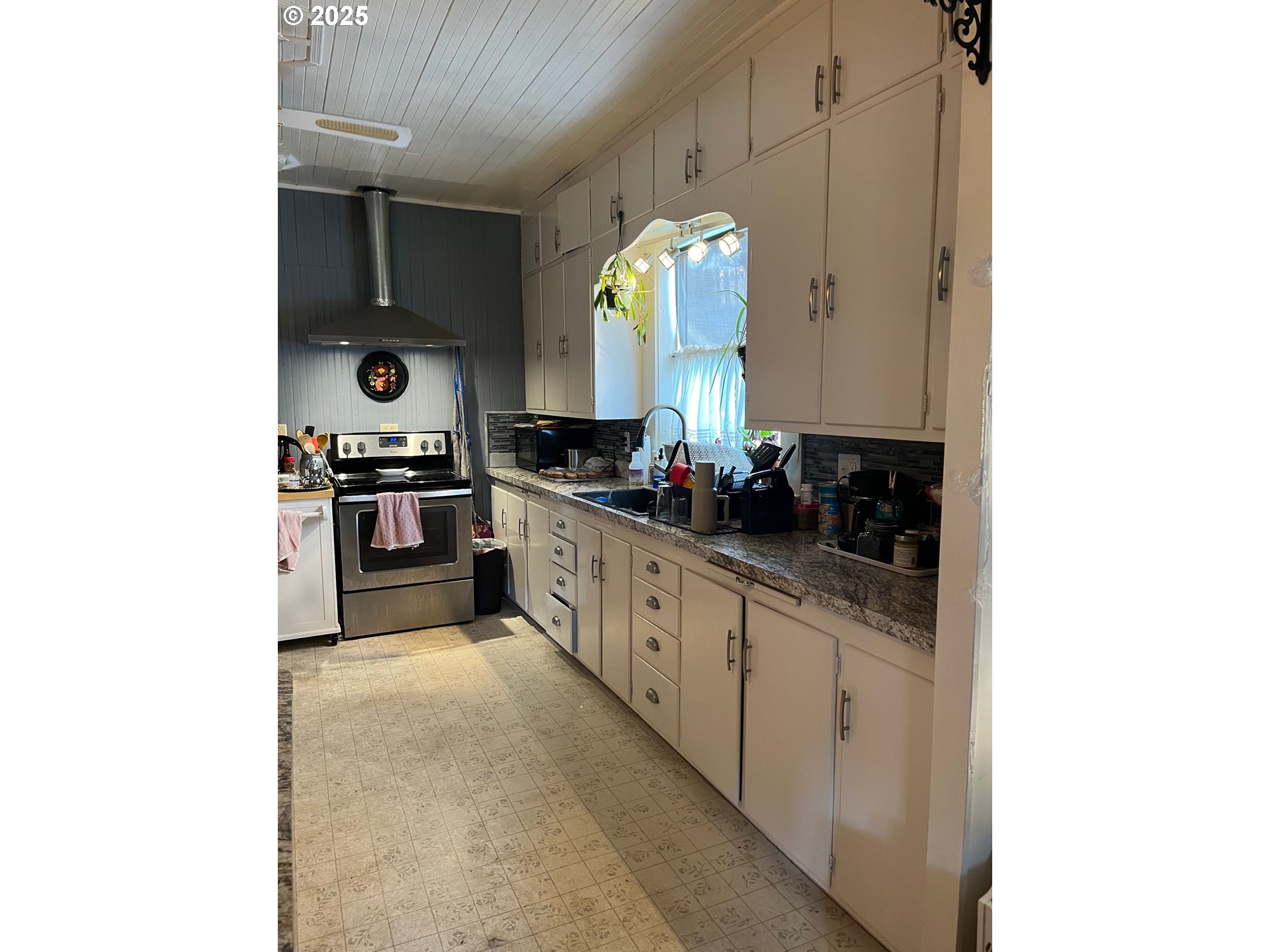 1205 49th Street Seaview, WA 98644 - Photo 15 of 36 a large kitchen with cabinets stainless steel appliances and a window