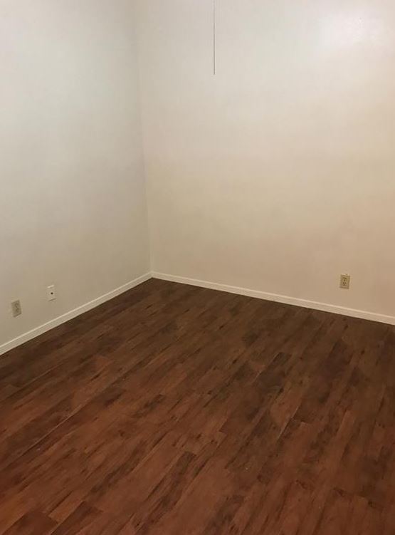 2604 Salado Street, Unit 301 Austin, TX 78705 - Photo 8 of 8 Spare room featuring dark wood-type flooring and baseboards