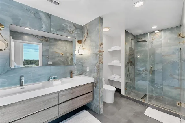 a bathroom with a double vanity sink toilet and shower