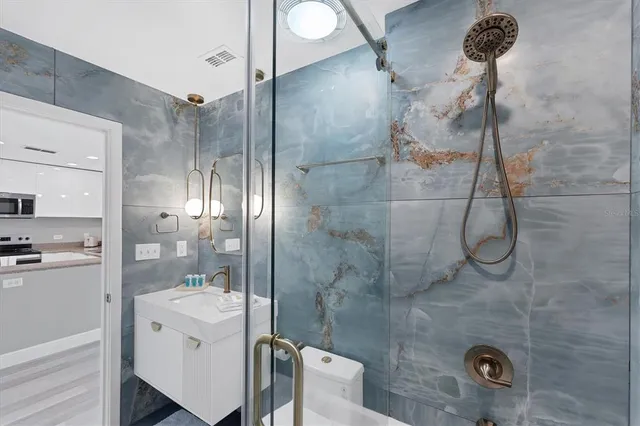 a bathroom with a sink a toilet and shower