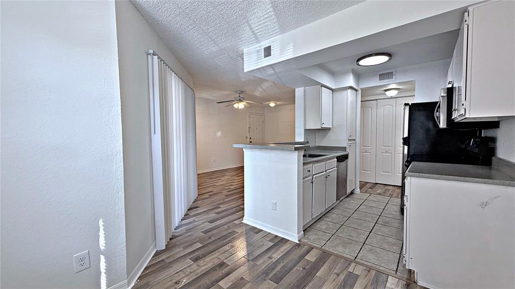 1037 South Hiawassee Road, Unit 2825 Orlando, FL 32835 - Photo 11 of 16 a kitchen with a refrigerator a stove top oven and a sink