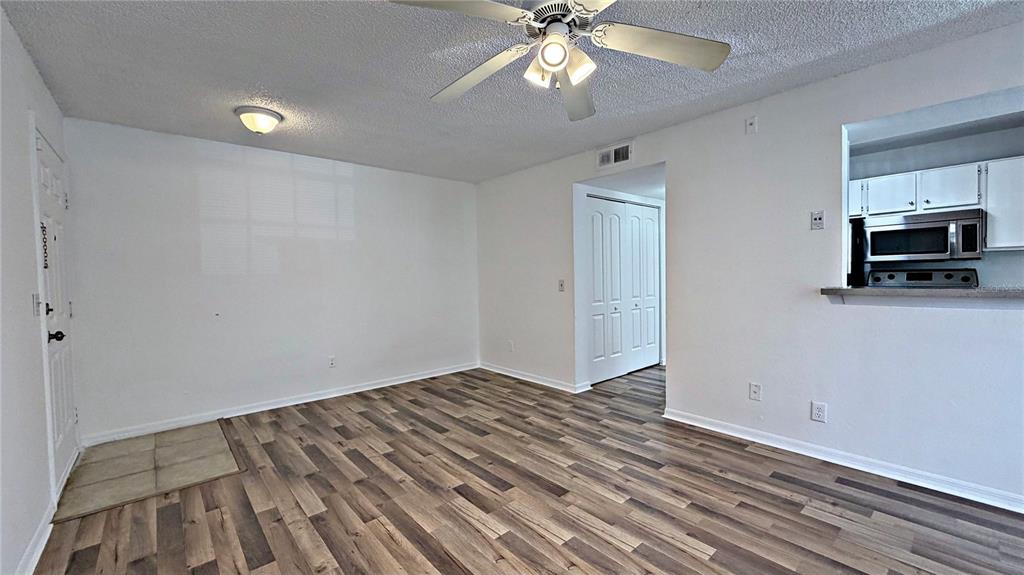 1037 South Hiawassee Road, Unit 2825 Orlando, FL 32835 - Photo 8 of 16 a view of empty room with wooden floor and ceiling fan