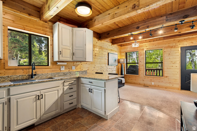 11237 East Aspen Road, Unit 74 Heber City, UT 84032 - Photo 11 of 32 Open-concept kitchen and living area featuring natural wood plank walls and exposed wood beams