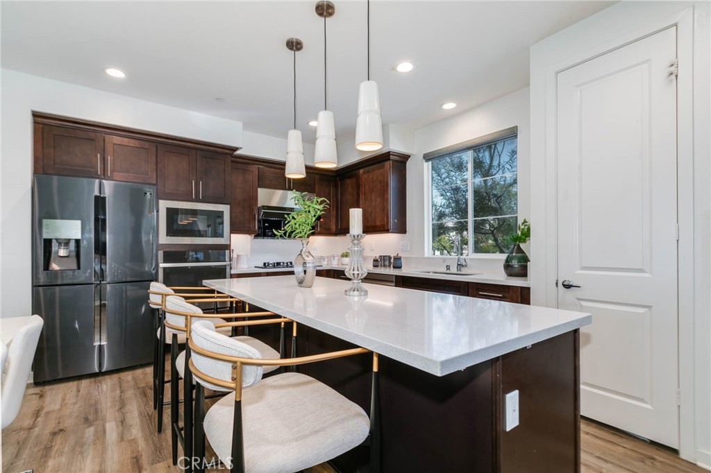 580 Cultivate Irvine, CA 92618 - Photo 5 of 30 a kitchen with a stove a refrigerator a sink dishwasher with a dining table and chairs