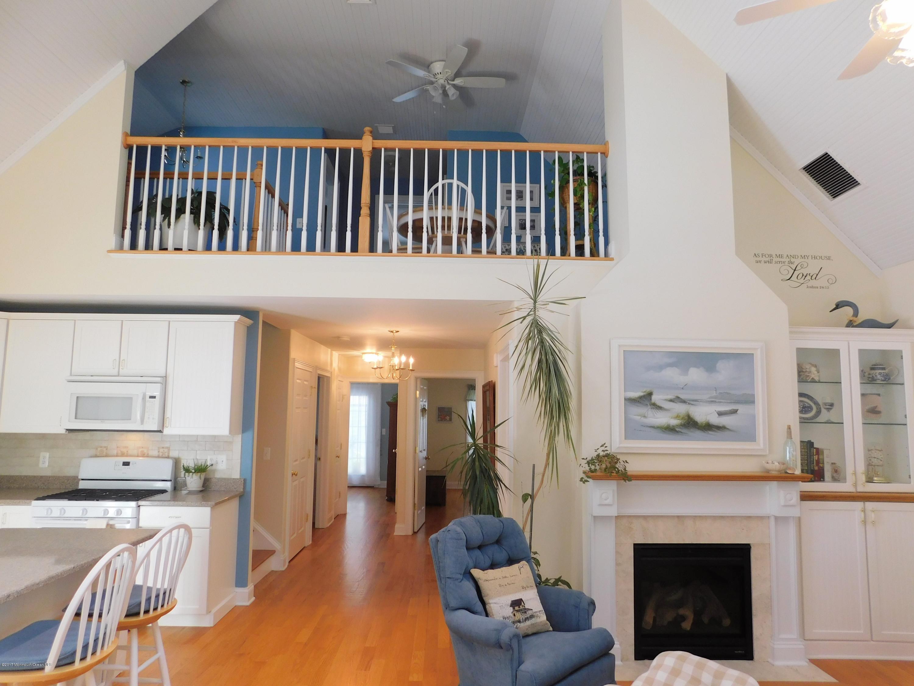 64 Manito Road Manasquan, NJ 08736 - Photo 6 of 26 a bedroom with furniture a fireplace and a chandelier