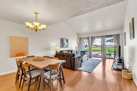a view of a dining room with furniture a chandelier and wooden floor