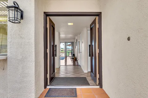 a dining room with chandelier and wooden floor