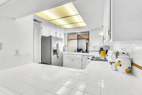 a kitchen with a sink a refrigerator and wooden cabinets