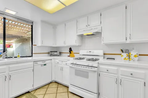 a kitchen with white cabinets and white appliances