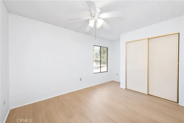 an empty room with windows and fan
