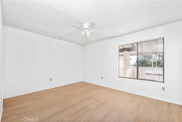 an empty room with a window and a fan
