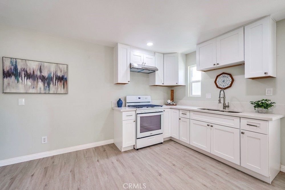 5510 Bushnell Avenue Riverside, CA 92505 - Photo 16 of 23 a kitchen with a white cabinets and wooden floor