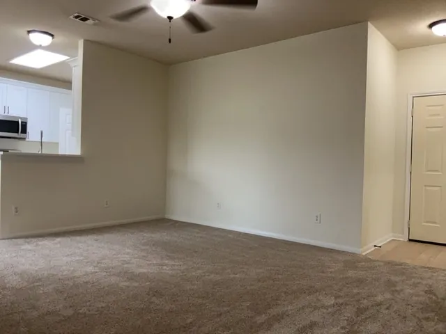 a view of an empty room with a chandelier fan