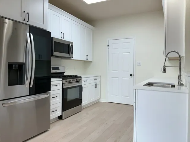 a kitchen with stainless steel appliances a refrigerator stove and sink