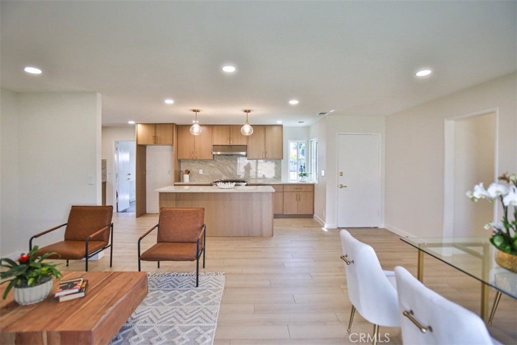 6401 Royal Oak Drive Huntington Beach, CA 92647 - Photo 14 of 49 a open kitchen with stainless steel appliances kitchen island granite countertop a dining table chairs and granite counter tops