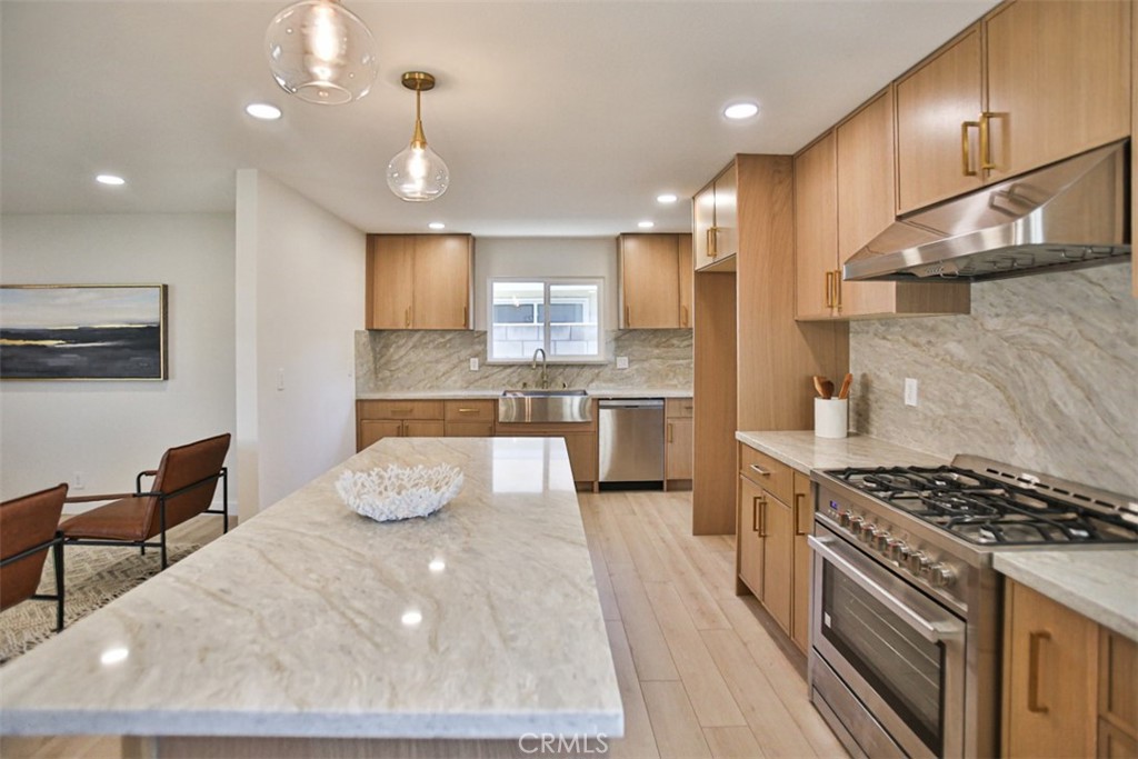 6401 Royal Oak Drive Huntington Beach, CA 92647 - Photo 32 of 49 a kitchen with stainless steel appliances granite countertop a sink stove and refrigerator