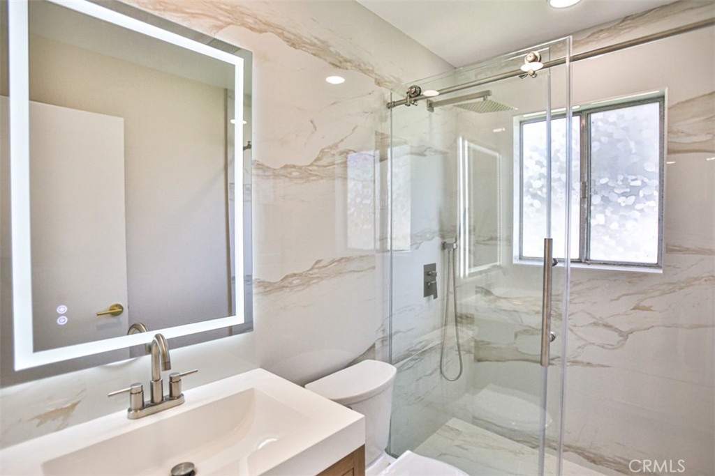 6401 Royal Oak Drive Huntington Beach, CA 92647 - Photo 38 of 49 a bathroom with a shower sink and mirror