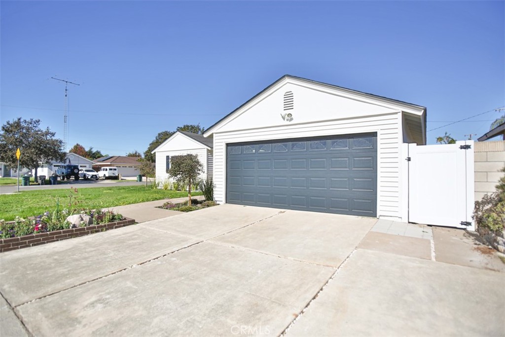 6401 Royal Oak Drive Huntington Beach, CA 92647 - Photo 4 of 49 a front view of a house with a yard and garage
