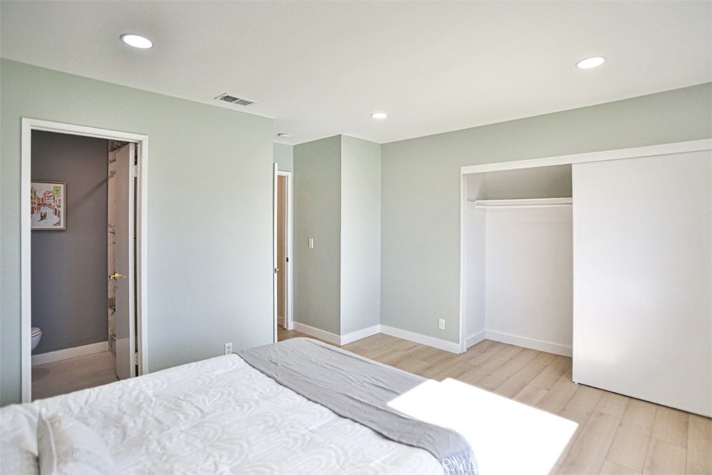 6401 Royal Oak Drive Huntington Beach, CA 92647 - Photo 42 of 49 a bedroom with a bed and wooden floor