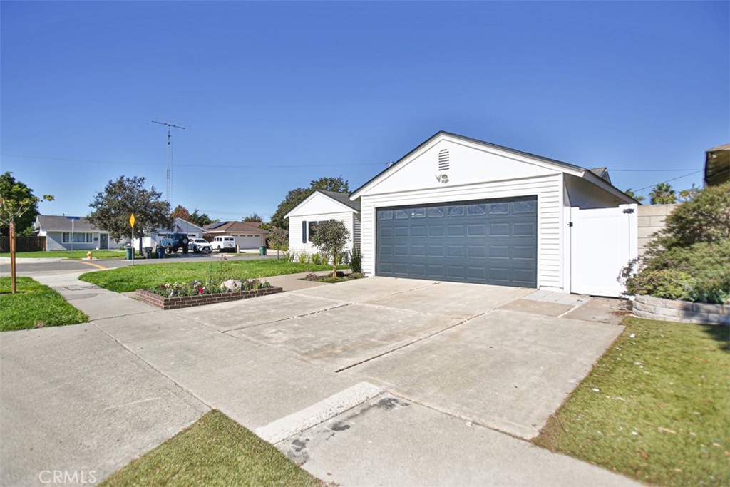 6401 Royal Oak Drive Huntington Beach, CA 92647 - Photo 6 of 49 a front view of a house with a yard and garage
