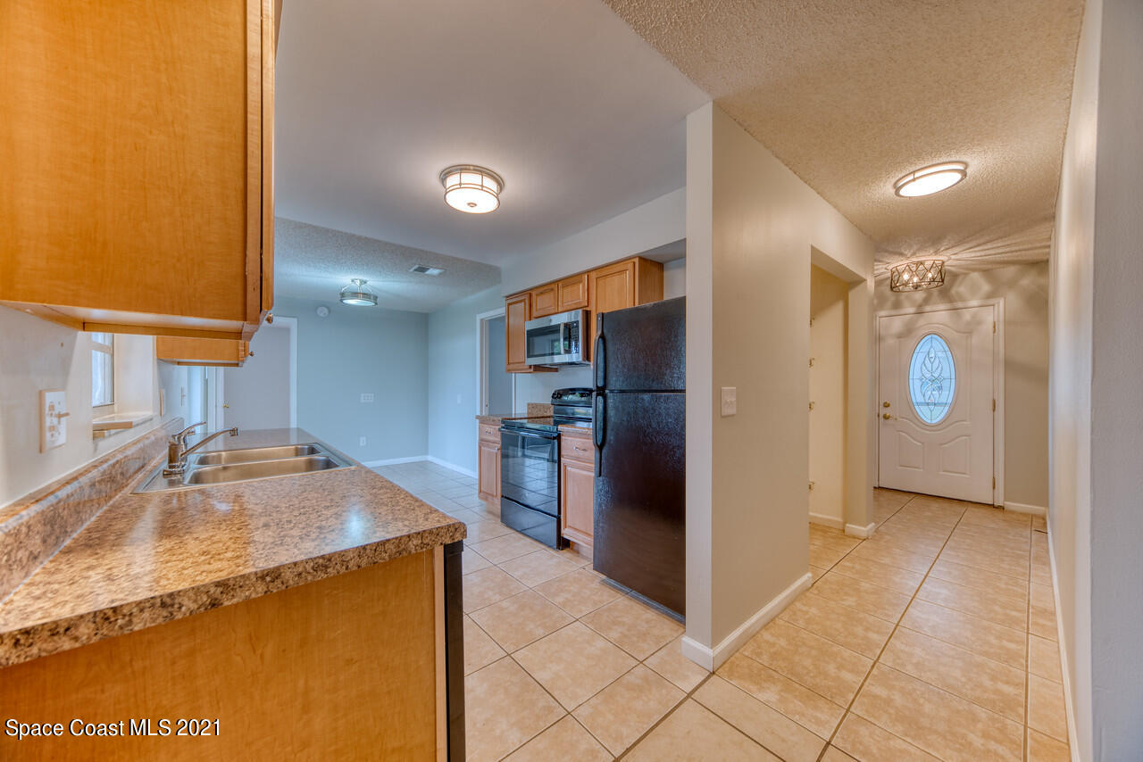 553 Edward Road West Melbourne, FL 32904 - Photo 2 of 26 a kitchen with stainless steel appliances granite countertop a sink and a refrigerator