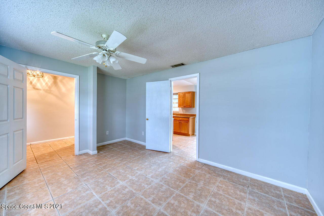 553 Edward Road West Melbourne, FL 32904 - Photo 12 of 26 an empty room with a ceiling fan and a window
