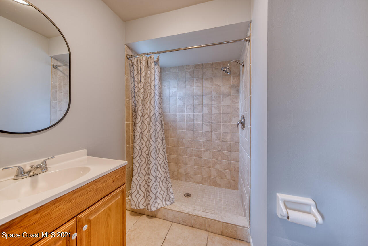 553 Edward Road West Melbourne, FL 32904 - Photo 14 of 26 a bathroom with a sink a mirror and a shower