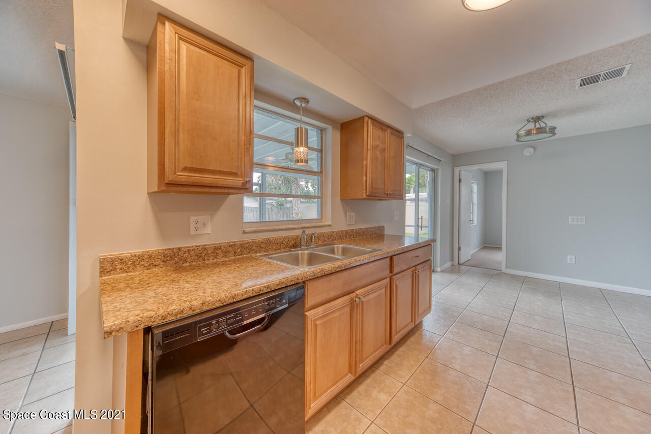 553 Edward Road West Melbourne, FL 32904 - Photo 3 of 26 a kitchen with a sink stove and cabinets