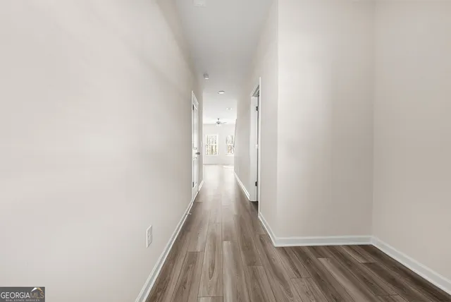 a view of a hallway with wooden floor