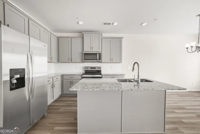 a kitchen with appliances a sink and cabinets