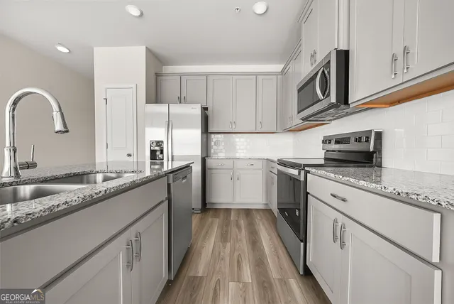 a kitchen with granite countertop white cabinets and white appliances